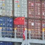 Infographic showing a downward arrow over a shipping container, labeled "935 Items" and "China Import Tariffs 2026."
