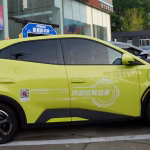 A side-by-side view of a Canadian cargo port and a row of modern Chinese electric vehicles ready for export