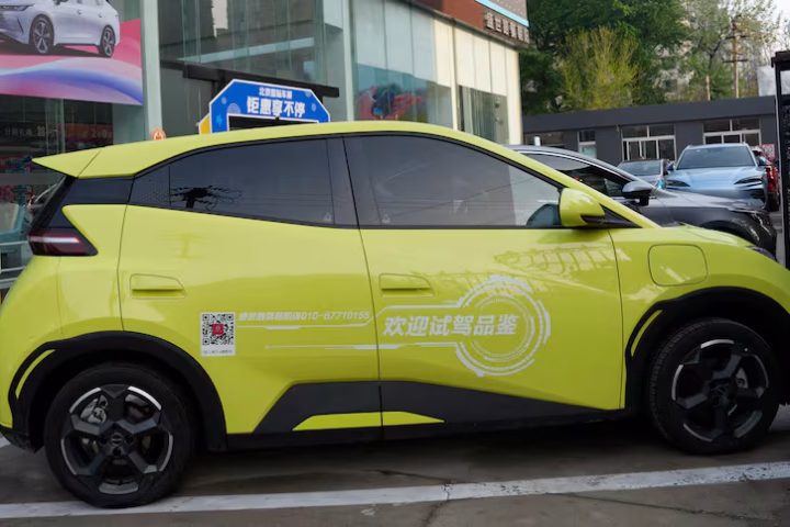 A side-by-side view of a Canadian cargo port and a row of modern Chinese electric vehicles ready for export